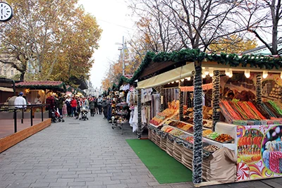 Xmas decorated wooden booths lining a path on Erzsébet Square in on a cloudy late November day