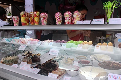 the stall of Sugar with cakes, macarons, lolipops, in the counter