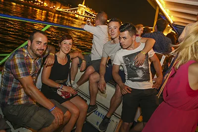 Half a dozen young party people on a boat on the Danube in Budapest at night