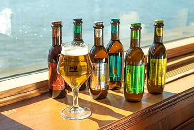 6 bottles of craft beer and a mug of beer in the window of  acruise ship