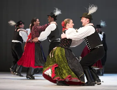 Hungarian folk dance perfomnce - 3 couples dressed in traditional folk costume dancing on a stage