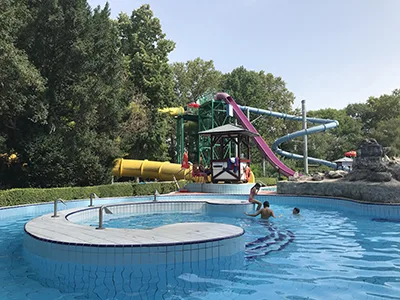 one of the adventure pools and color coded giant slides behind it at Punkosdfurdo Lido (open-air bath)