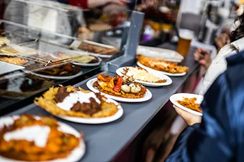 5 plates of placed on the black counter of a food both at the Spring & Easter Market