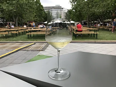 a glass of white wine placed on black table top on the wine festival in May in Budapest