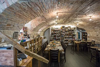 a vaulted stone cellar In Budapest city centre with tasting tables and racked wines