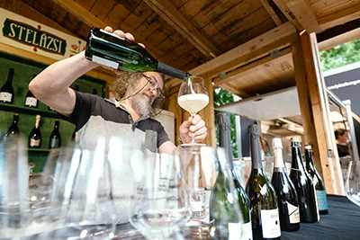 A server pouring champagne in a glass on the Budapest Wine c Champagne Festival