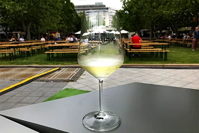 a glass of white wine on a table on the Downtown Budapest Wine & Champagne Festival