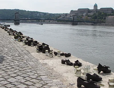 Shoes On The Danube Memorial: 60 pairs of cast iron shoes on the Danube bank in Pest. Flowers and candles placed between the shoes.
