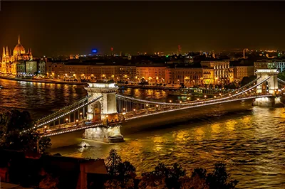 night view of the illuminated Chain Bridge and buildings on the Pest Danube bank