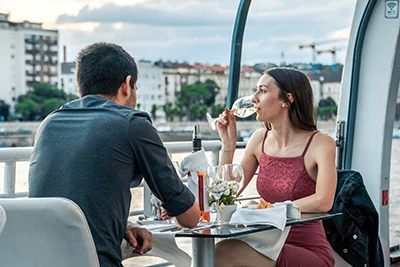 a young couple drinking sparkling wine on a daytime Budapest cruise