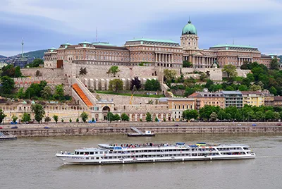 a large, white sightseeing boat on the Danube at Buda castle