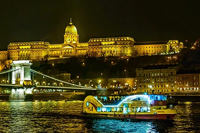 Cheap Budapest Cruises: Wiking catamaran cruise boat on the Danube near the Chain bridge at night.