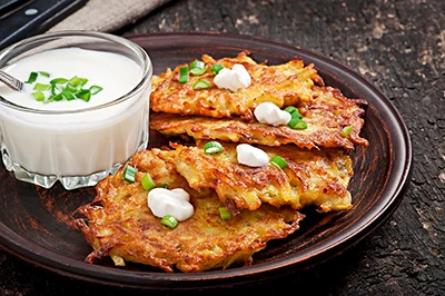 4 pieces of fried potato pancakes served with sour cream