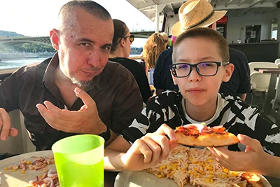 my husband and 12 yr old son eating their pizzas on the Danube cruise