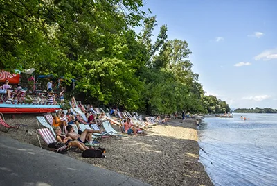 Romai parti Beach in Budapest on the Danube bank - colorful, striped beach chairs arranged nicely on the sandy riverbank