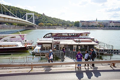 boarding place of Silver Line Cruises - two purple and white boats of the company are moored in the dock, next to Elizabeth Bridge