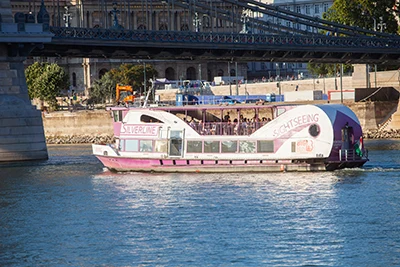 The white and purple color Wiking cruise baot at the Chain Bridge in Budapest