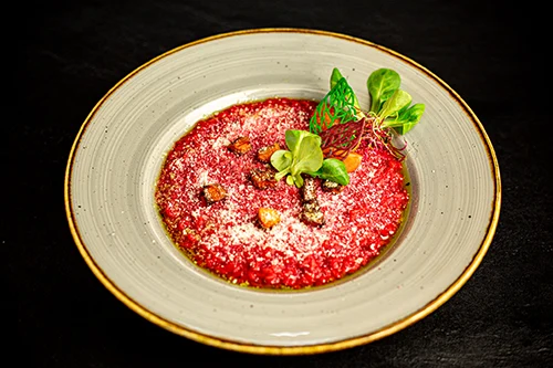 beetroot risotto in a round beige plate