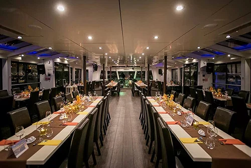 two rows of tables set for dinenr onboard a cruise ship