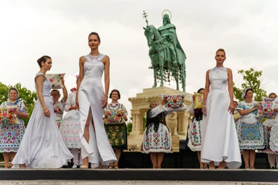 models wearing elegant white gowns on the Fashion showat the King St. Stephen's Statue