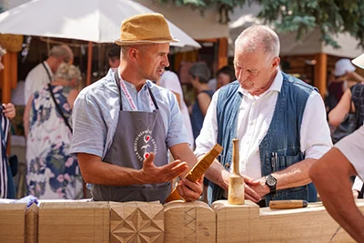 a wood working artist talking to a festival visitor