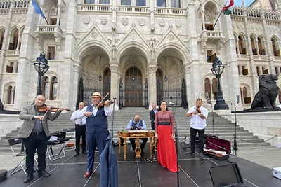 an orchestra and a female singer performing in front of the Parliament