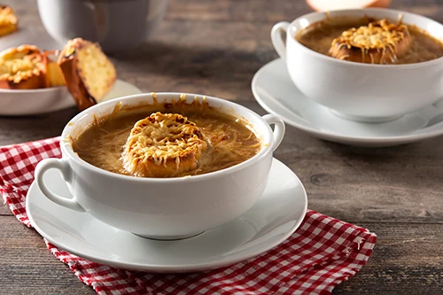 onion soup with cheese crouton in a white bowl