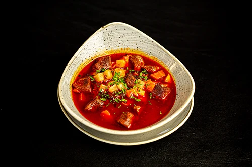 goulash soup in an oval shaped ceramic bowl