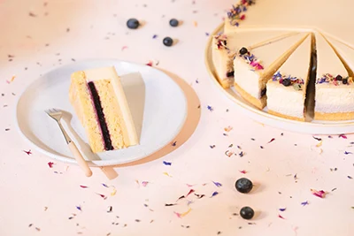 Photo of Hungary1s sugarfree cake 2023: a vanila flavoured white chocolate moussse cake (part of the whole torte can be seen with a slice placed on white plate to the right