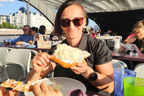 Me eating lángos with sour cream and cheese on an afternoon river cruise