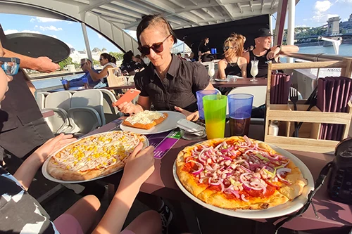 We've started to eat our pizzas and langos on the afternoon boat cruise