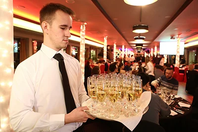 a young waiter with a tray of champagne in glasses