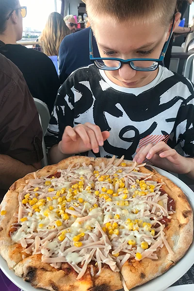 our son (12 yrs old) eating his ham and sweet corn pizza on the cruise