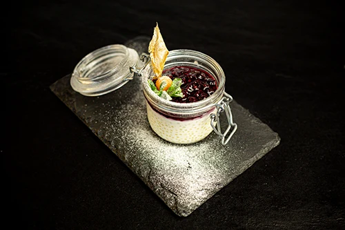 tapioca pudding with red berries puree in a small glass jar