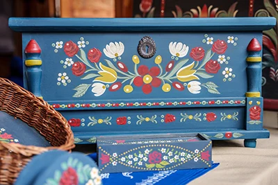 a blue wooden chest decorated with traditional flower motif paintings