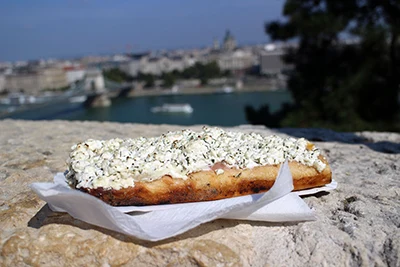 bread pizza with cheese and sour cream topping place on a stone wall in Buda castle