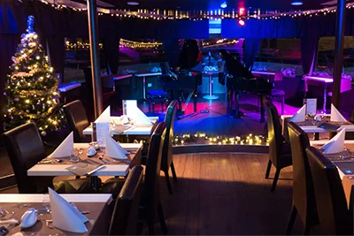 festive dinner setting and a Christmas tree on a cruise boat in Budapest