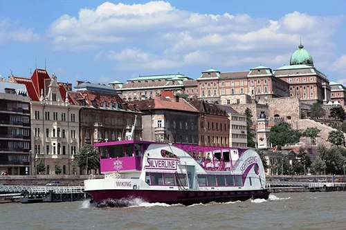a purple and white two-deck sightseeing boat of Silveline on the Danube during the day