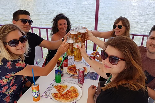 6 young people on the open deck of a booze cruise boat