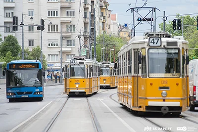 two trams (No. 47) and a blue bus in Budapest