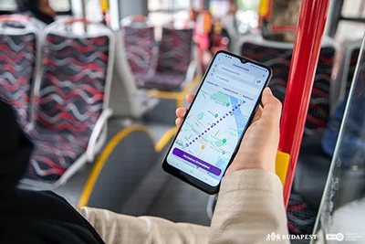 photo showing a hand holding a mobile phone on a bus