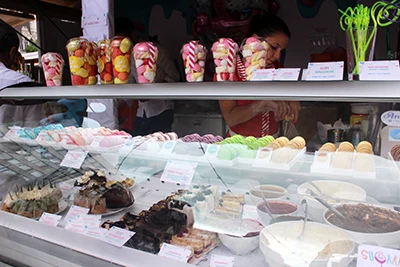 the booth of Sugar shop with cakes, macarons, lolipops in the counter