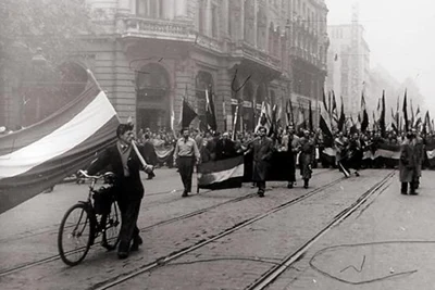 black and white photo of demonstrators with the national flag in their hands on the streets of Budapest in 1956