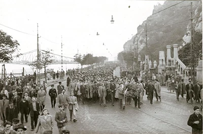 a black and white photo of the procession to the Bem statue on the Buda riverbank in 1956