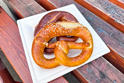 two Bavarian pretzels on a paper plate