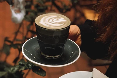 black latte in black cup in Fekete Coffee shop