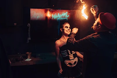 a fire juggler and a young laydy in a skeleton costume