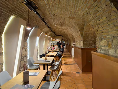 the vaulted interior of the Pálinka Museum with a couple of tables along the wall