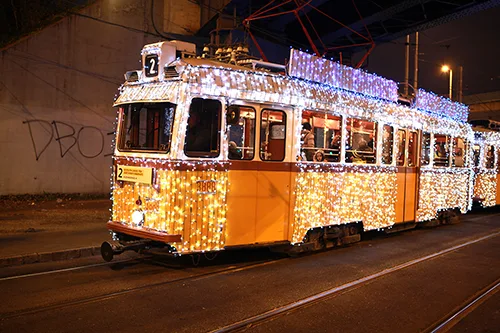 the yellow tram No. 2 with strings of LED light standing at one of its stops