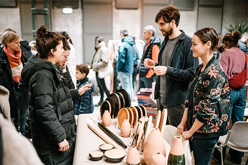visitors talking with pottery design artists on the makers' Market Fair
